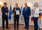 Innenminister Joachim Herrmann neben Lea Sophie Friedrich mit Urkunde, Vertreter des DPSK und Moderatorin