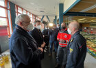 Innenminister Joachim Herrmann und weitere Personen im Gespräch in Turnhalle, die als Notunterkunft für Geflüchtete vorbereitet ist