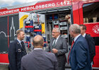 Innenminister Joachim Herrmann zusammen mit weiteren Teilnehmern im Gespräch vor Feuerwehrfahrzeug