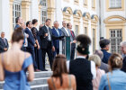 Ministerpräsident Dr. Markus Söder und Ministerinnen und Minister, einschließlich Herrmann, auf Steintreppe vor dem Schloss, im Vordergrund Publikum von hinten