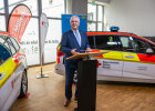 Innenminister Joachim Herrmann am Rednerpult zwischen zwei neuen Rettungseinsatzfahrzeugen