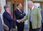 Innenminister Joachim Herrmann schüttelt einer Frau die Hand, weitere Personen am Eingang