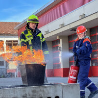 Feuerwehrmann und Kind bei Feuerlöschübung