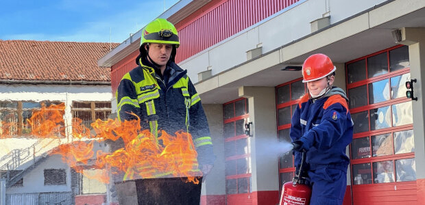 Feuerwehrmann und Kind bei Feuerlöschübung