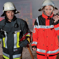 Ein Feuerwehrmann und eine Frau des BRK mit Digitalfunkgerät Ein Feuerwehrmann und eine Frau des BRK mit Digitalfunkgerät