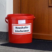 Löscheimer vor einer Haustür Löscheimer vor einer Haustür