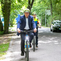 Innenminister Joachim Herrmann auf dem Polizeifahrrad neben zwei weiteren Polizisten auf Fahrrädern