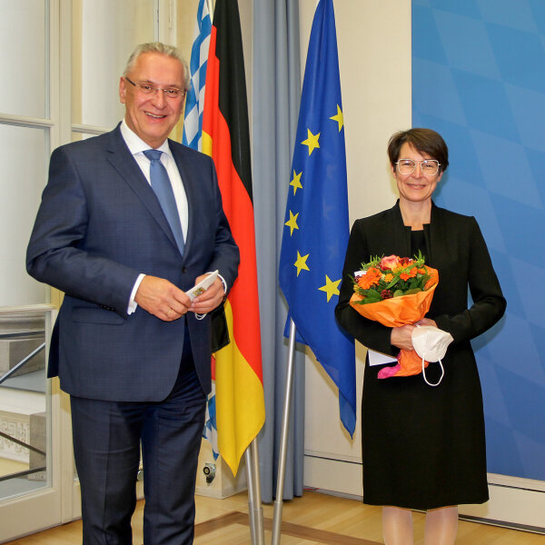 Innenminister Joachim Herrmann und Gewinnerin mit Blumenstrauß sowie Joseph Ströbl